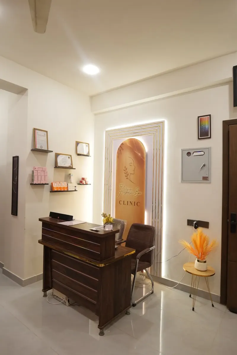Reception desk at The Aesthetic Bar Clinic with the clinic logo lit behind it
