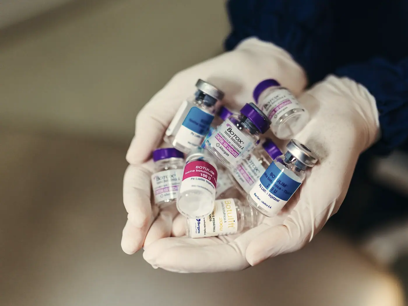 Gloved hands holding treatment vials in a clinic