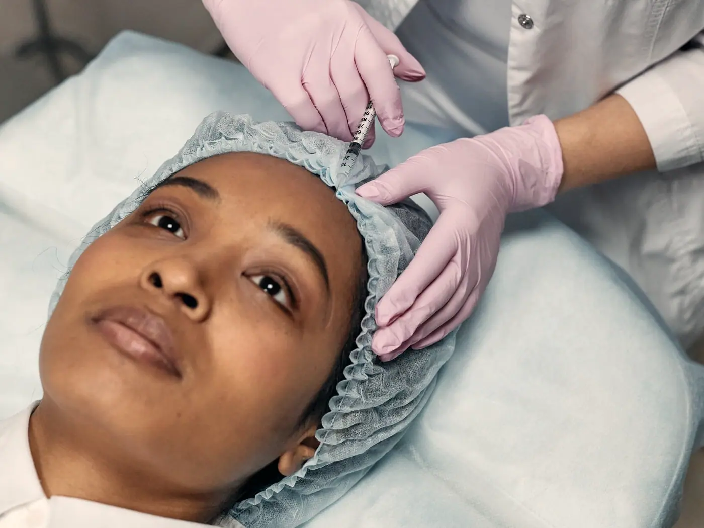 A clinician administering an injectable treatment to the forehead