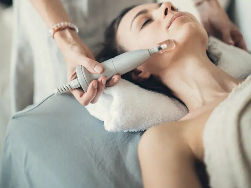 A facial treatment being carried out with a handheld device