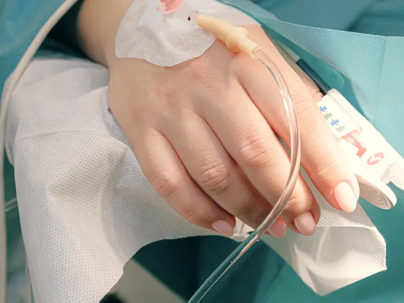 An intravenous line running into a patient’s hand