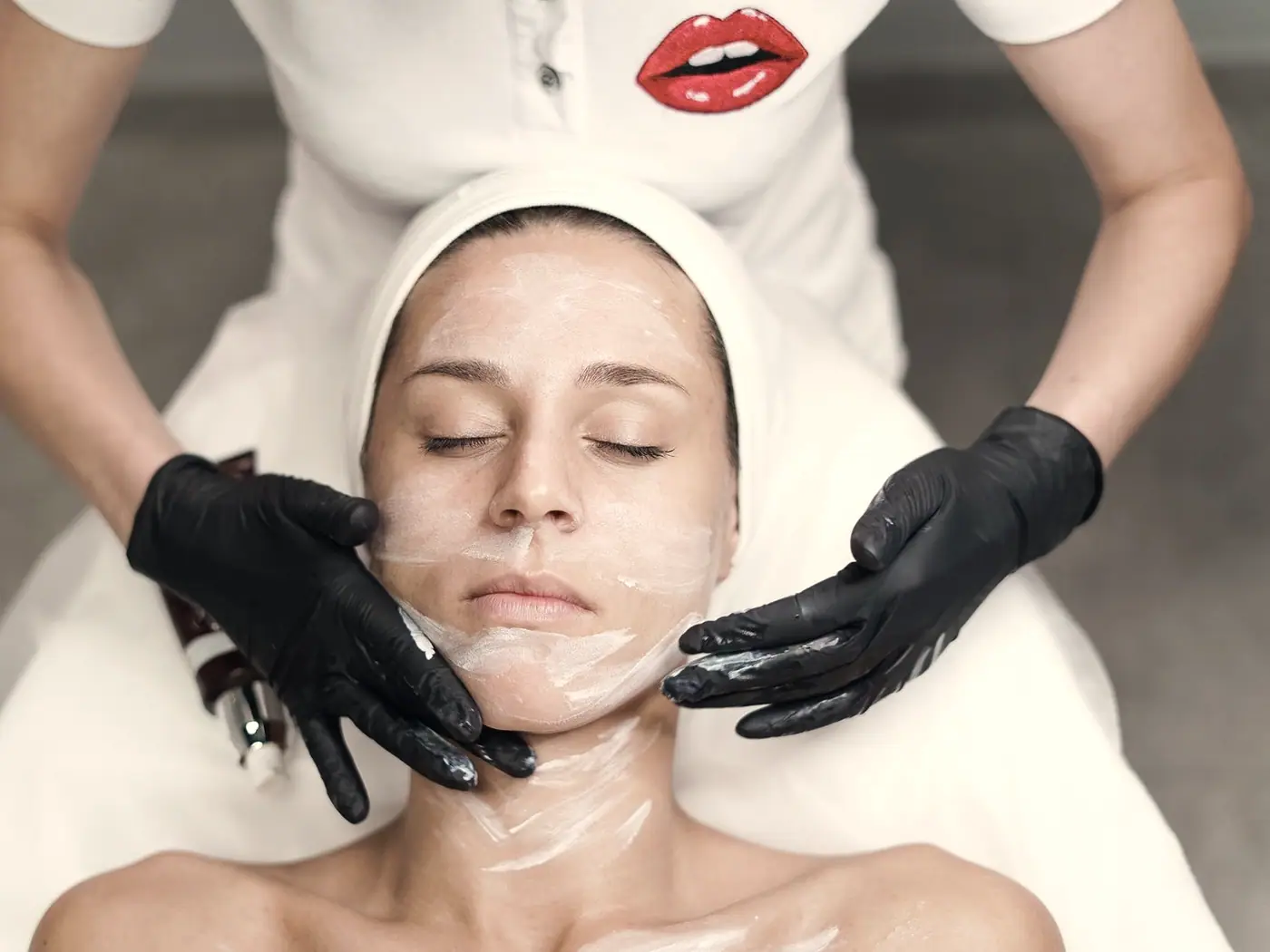 A treatment mask being applied to the face during a skin treatment