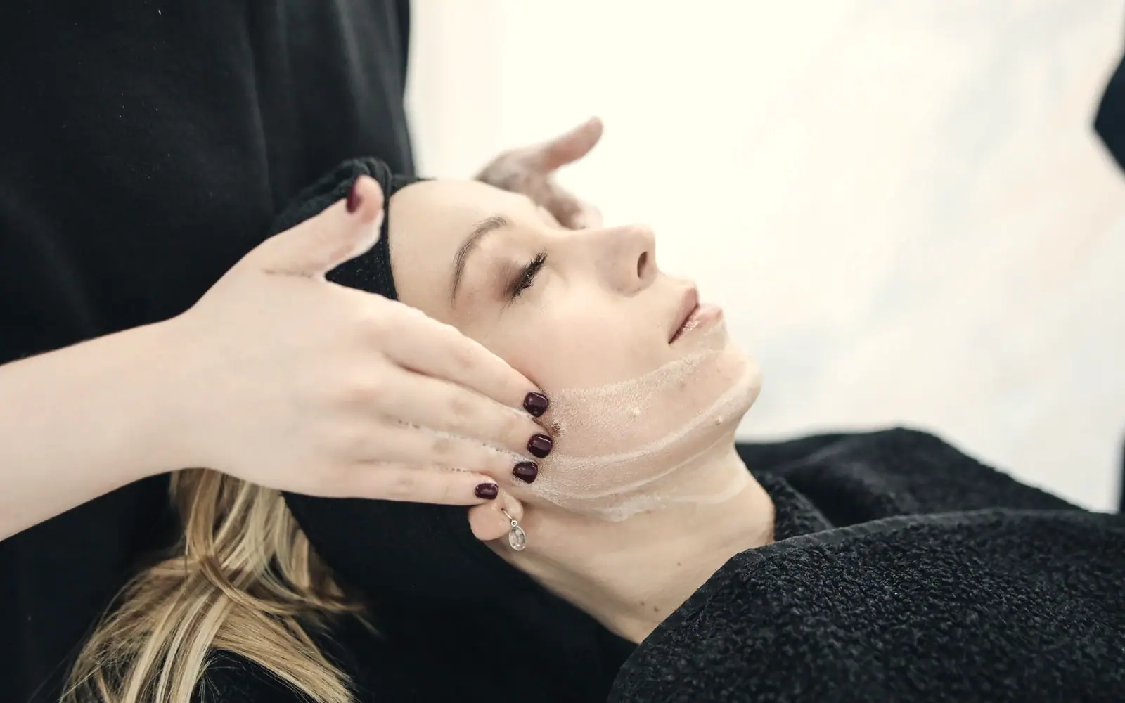 A calm treatment room with a client resting during a facial